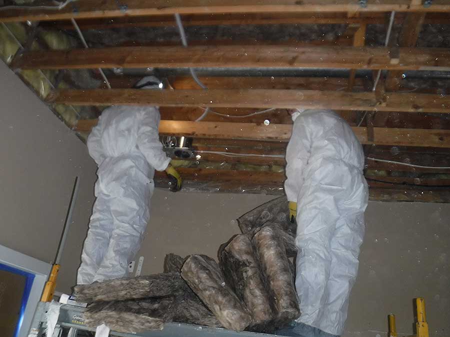 Workers installing insulation in a home to enhance energy efficiency