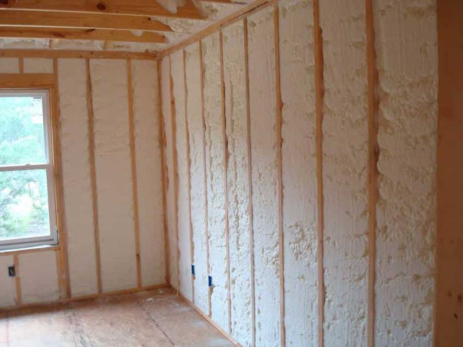 Spray foam cavity insulation applied in a wood-framed wall for thermal efficiency