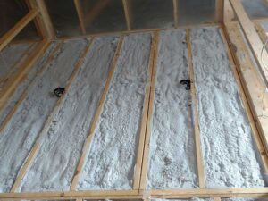 Spray foam insulation applied between wooden studs for wall insulation